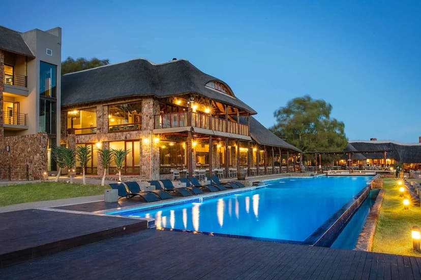 Luxury lodge at dusk with reflective pool