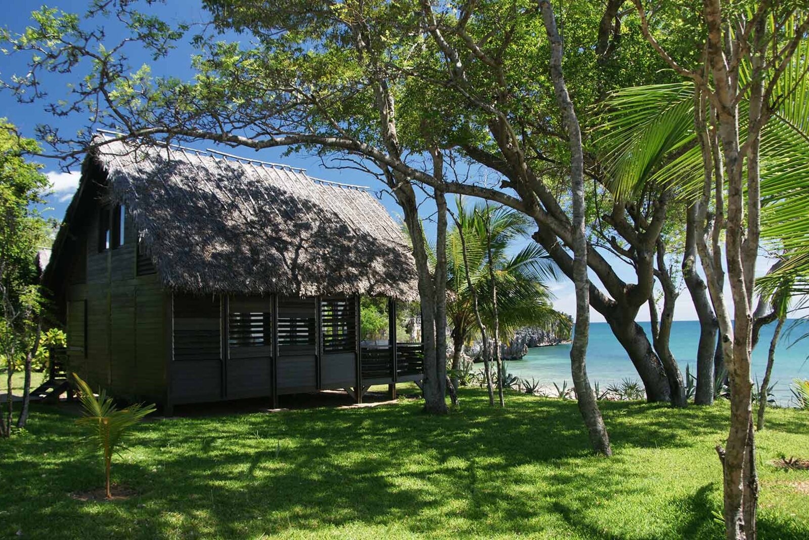 Thatched rosewood villas set among trees beside the beach at Anjajavy le Lodge, Madagascar
