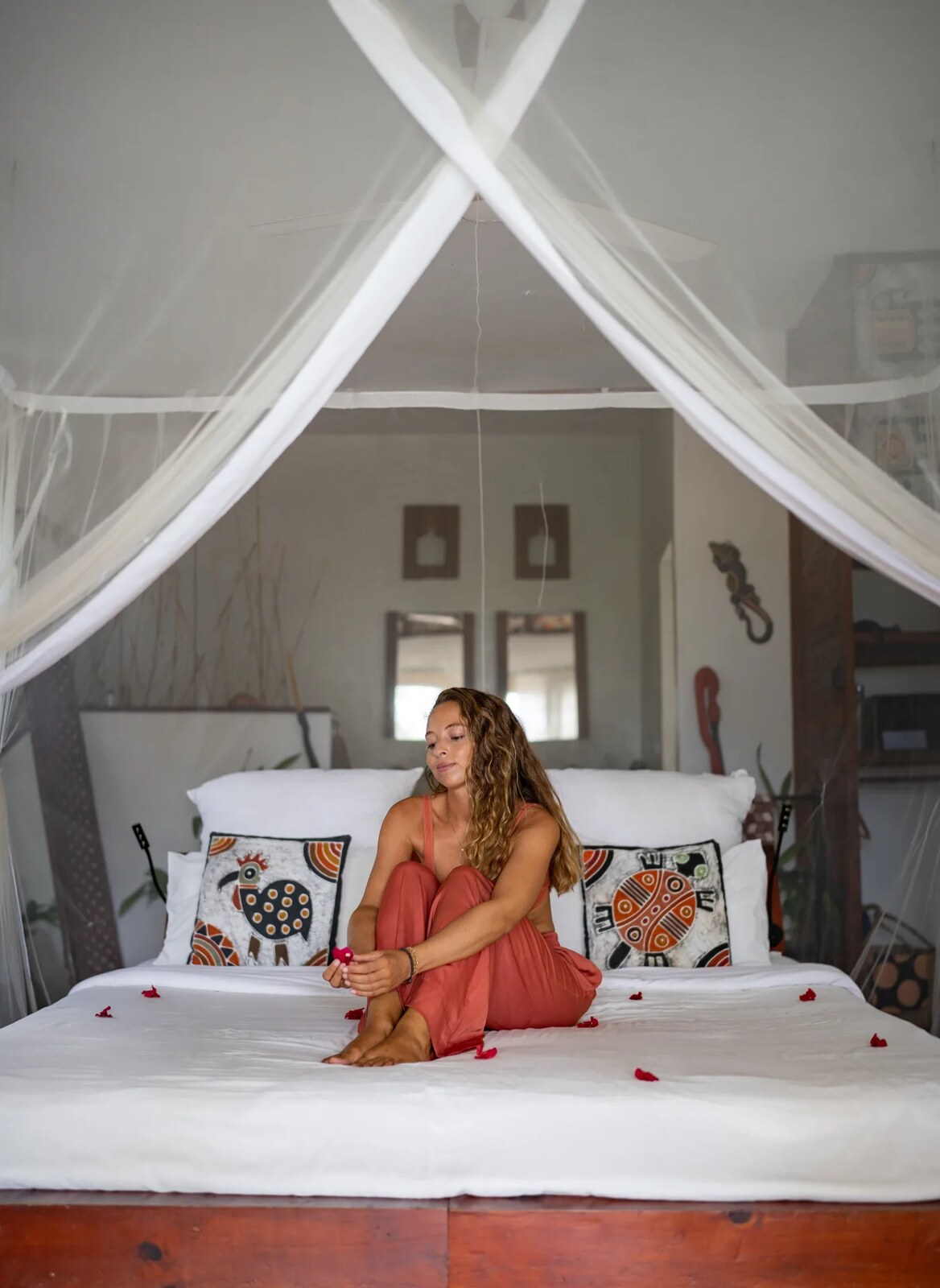 Bungalow interior with a canopy bed, mosquito net and Mozambican textiles at Baía Sonâmbula, Tofo, Mozambique