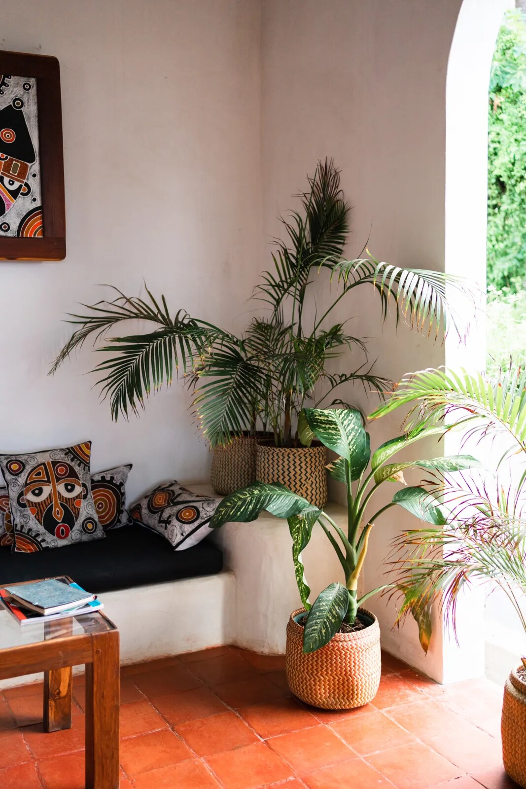 Plant-filled lounge with terracotta floors, Mozambican cushions and a daybed at Baía Sonâmbula, Tofo, Mozambique