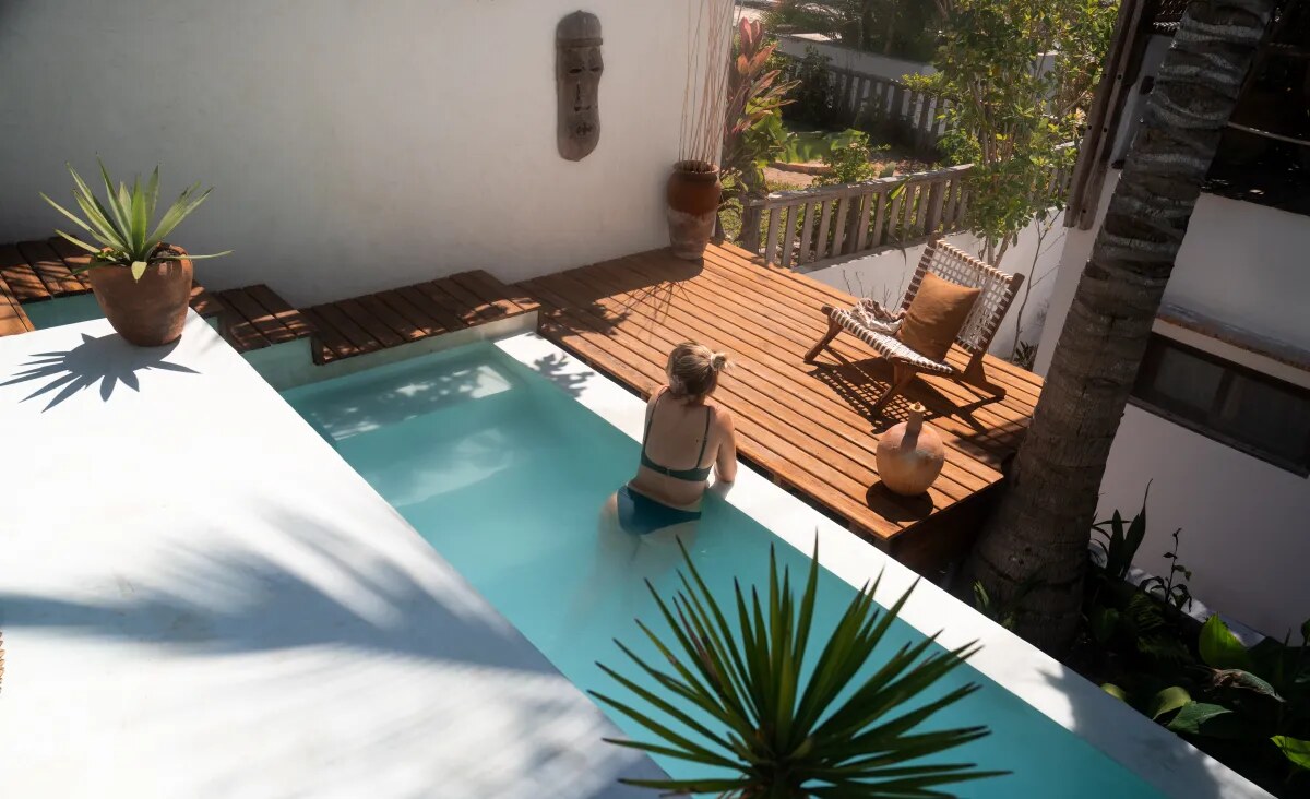 Plunge pool on a wooden deck framed by palms at Baía Sonâmbula, Tofo, Mozambique