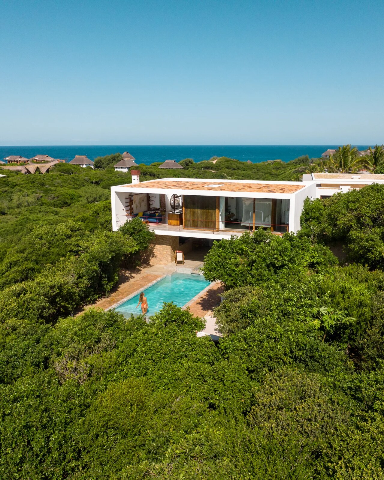 Aerial view of a Baía Sonâmbula villa and private pool set in green above the ocean at Tofo, Inhambane, Mozambique