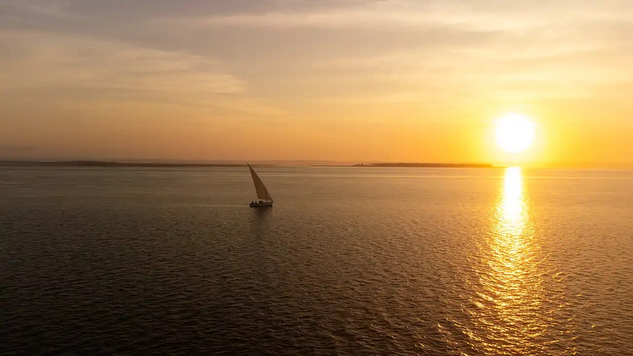 Traditional dhow sailing on Inhambane Bay at sunset near Tofo, Mozambique