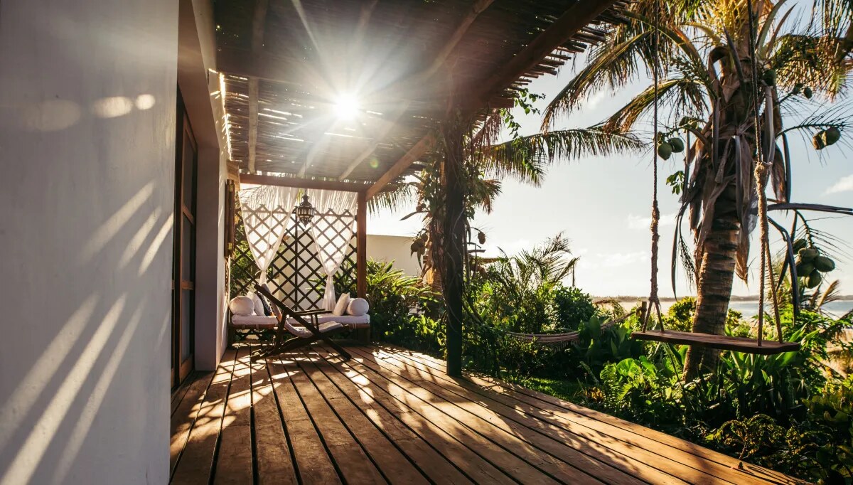 Private wooden deck terrace framed by palms with sea views at Baía Sonâmbula, Tofo, Mozambique