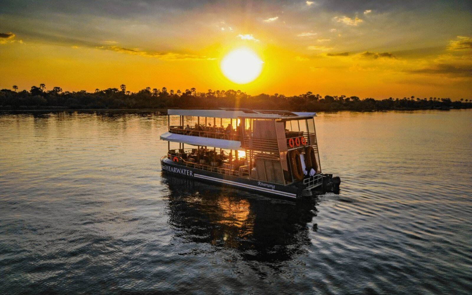 A sunset cruise on the Zambezi River with the sky glowing gold