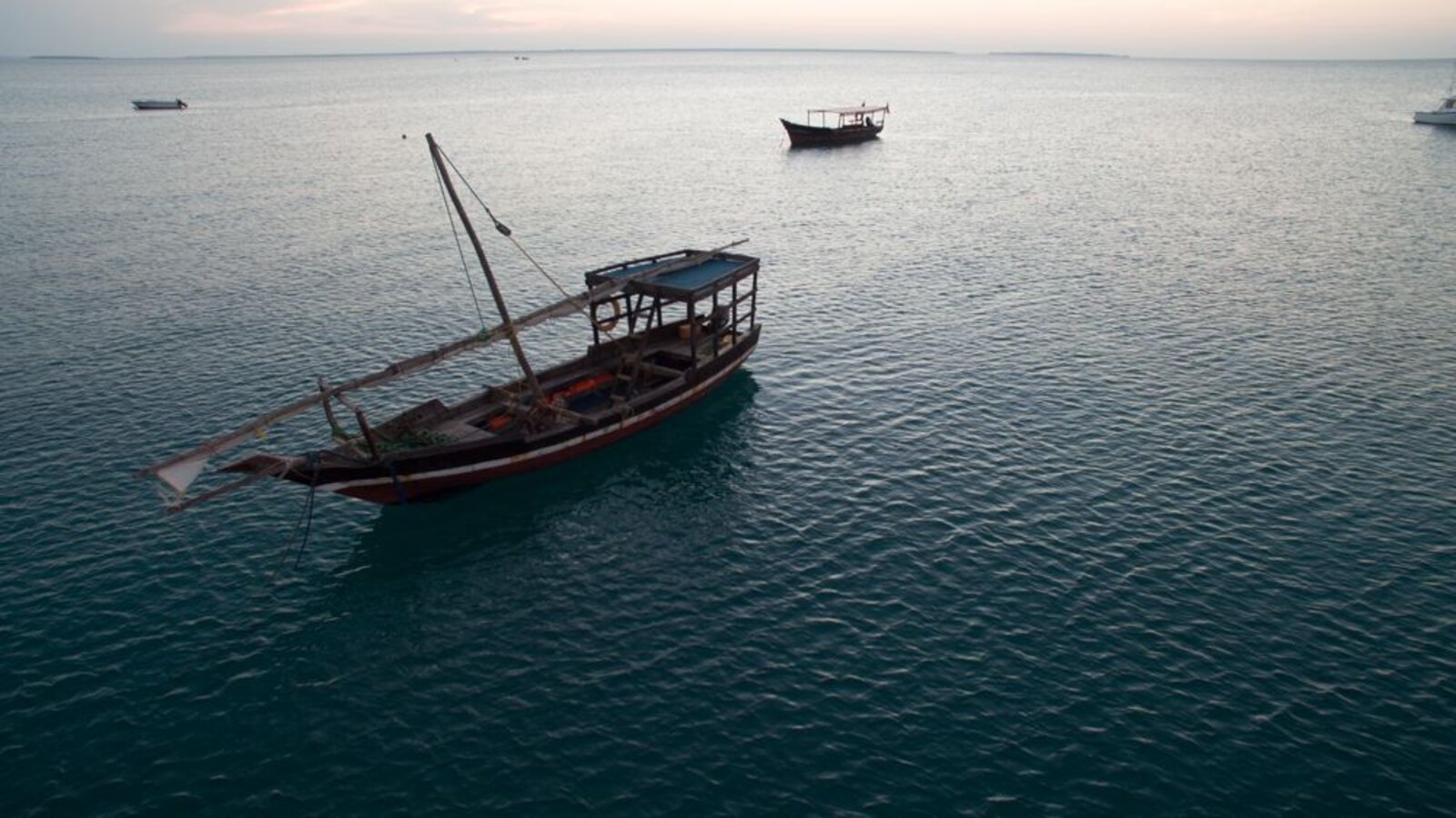 Traditional dhow sailing at sunset off Zanzibar coast
