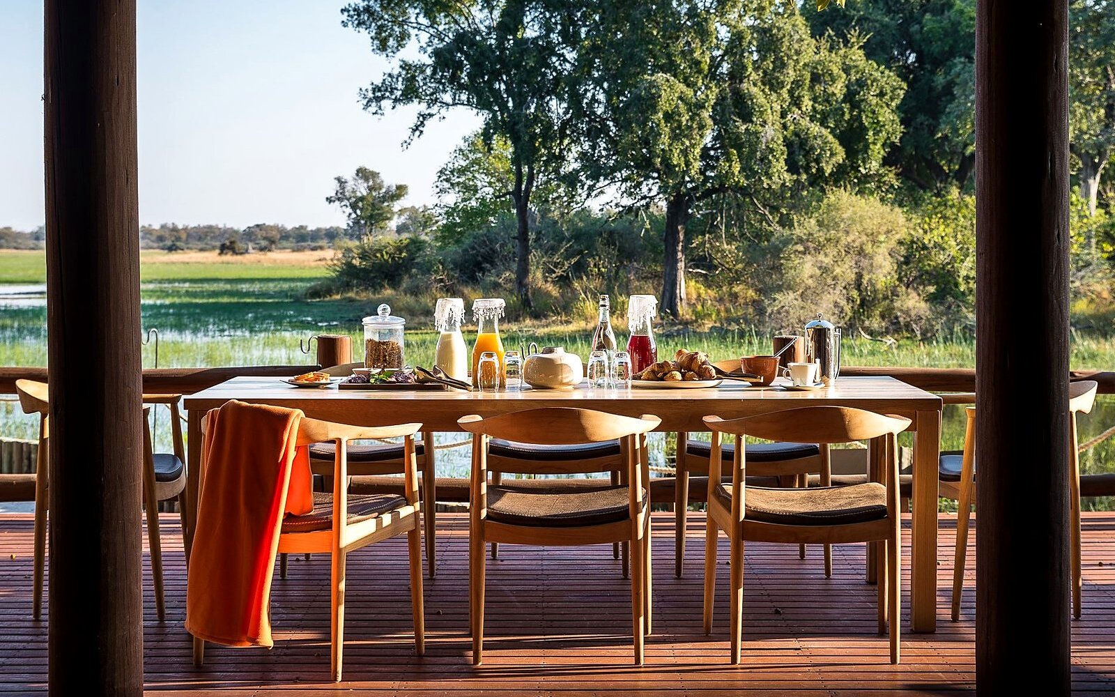 An outdoor dining table beautifully set for a meal overlooking the delta at Chief's Camp