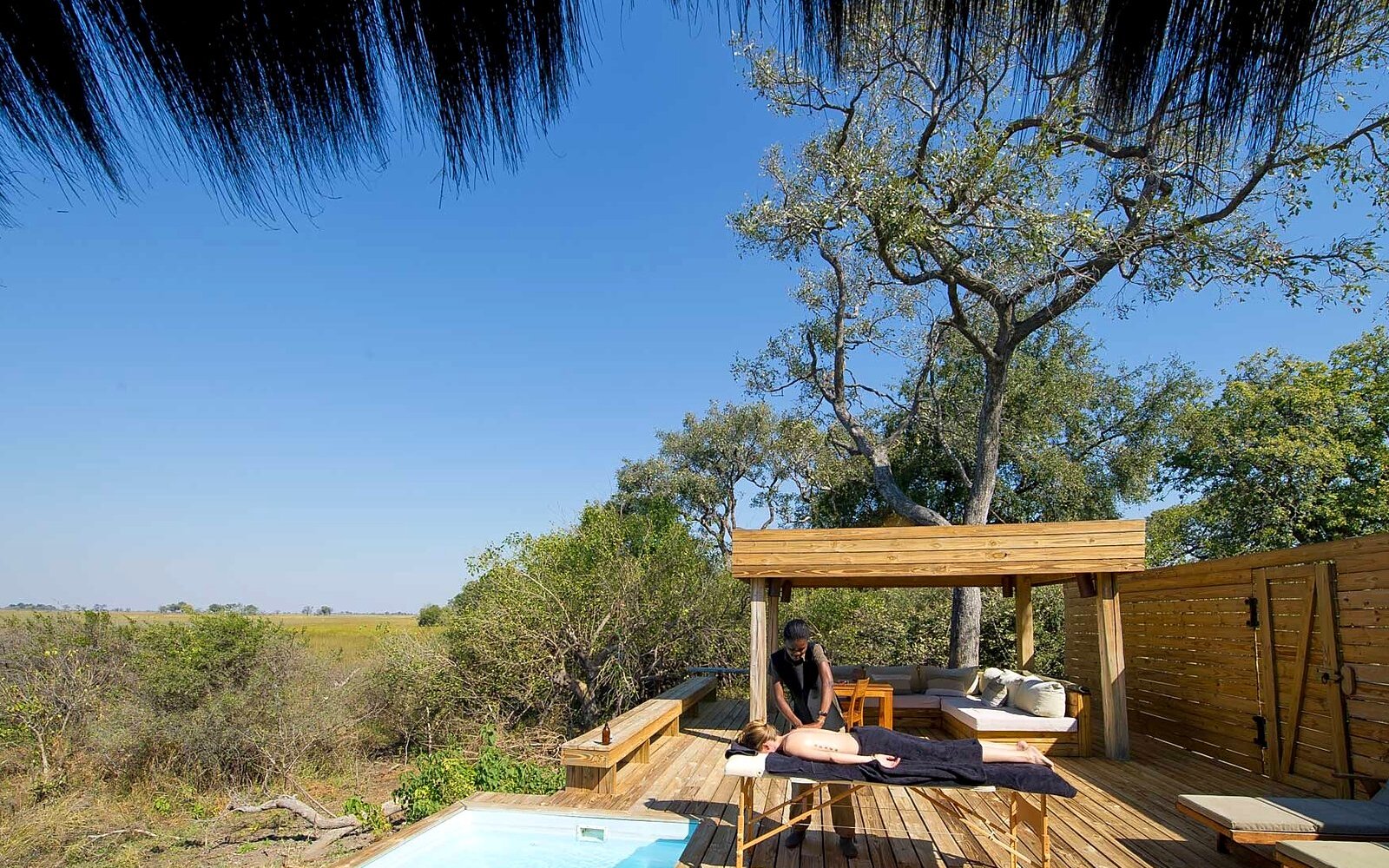 A raised timber suite deck with a plunge pool overlooking the Okavango floodplain at Vumbura Plains