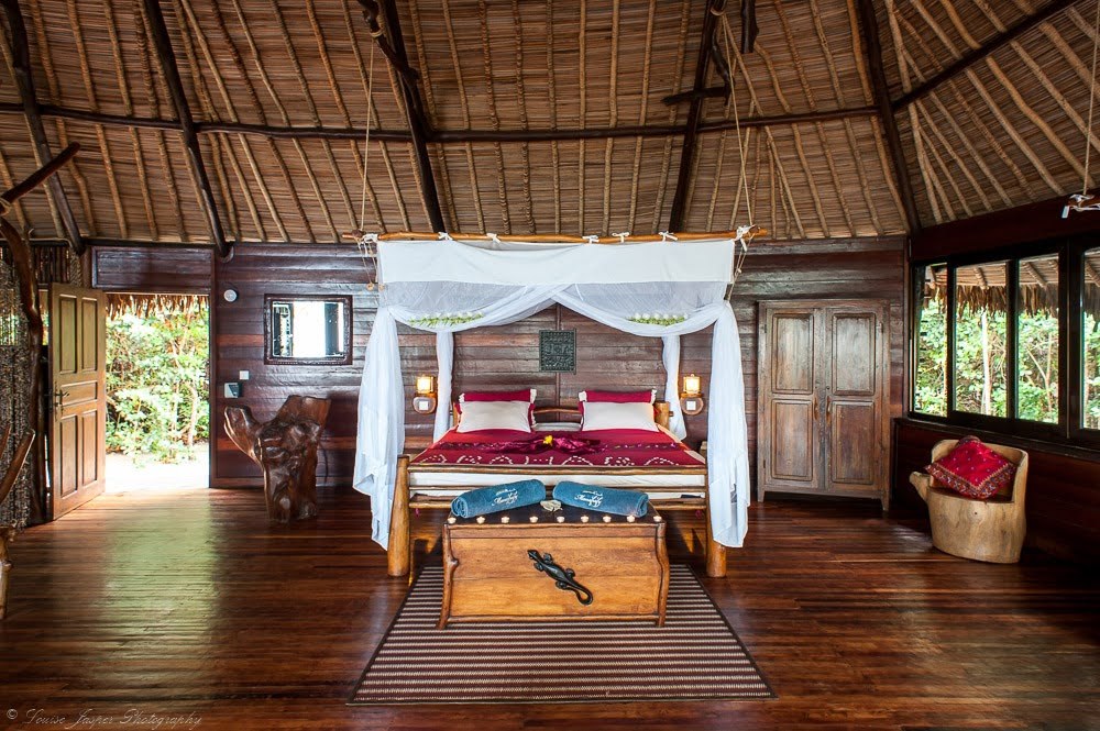 Interior of a beachfront bungalow bedroom at Manafiafy Beach & Rainforest Lodge opening onto the forest, southeast Madagascar