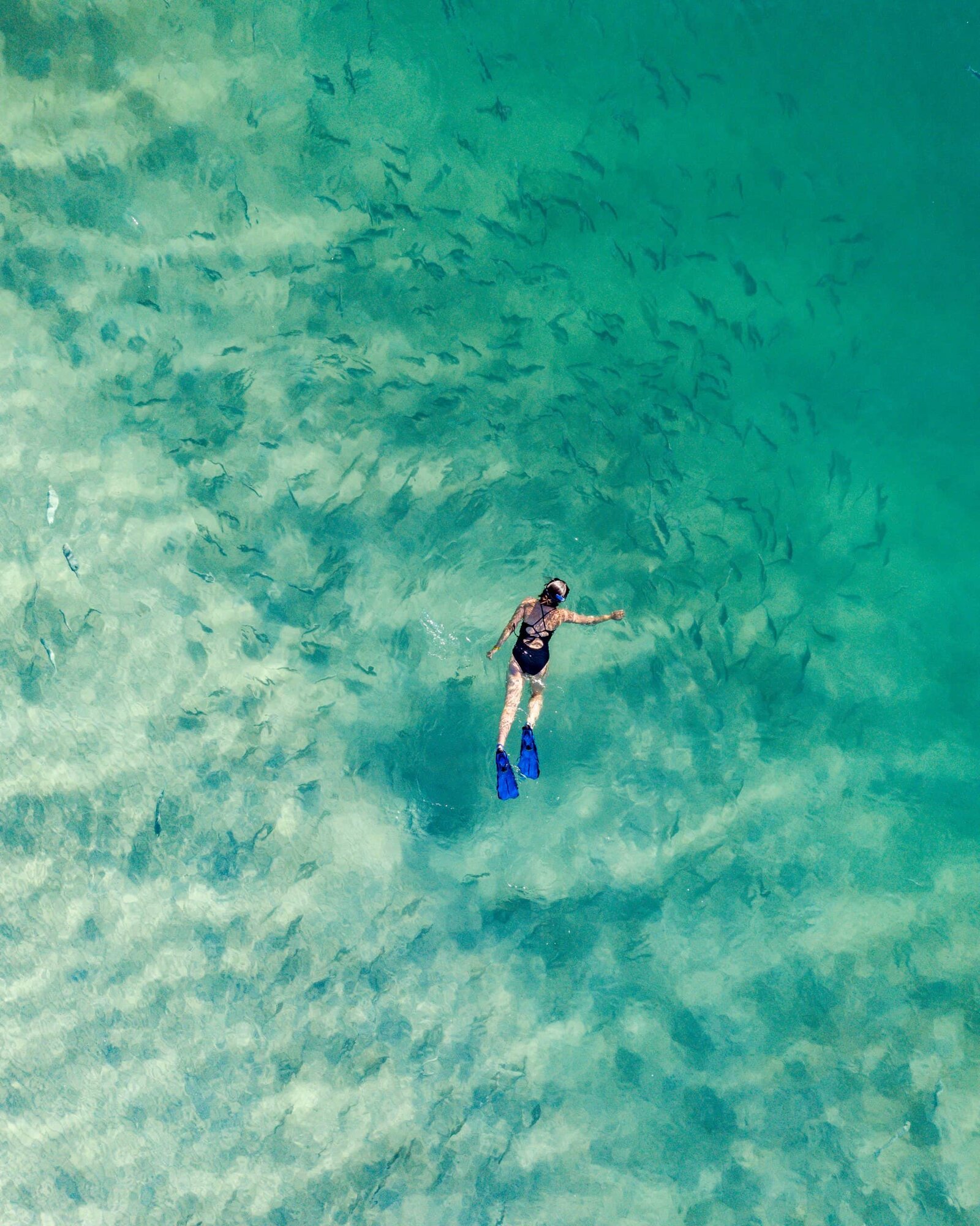 Aerial view of a snorkeller in the turquoise lagoon off Nosy Ankao at Miavana, northern Madagascar