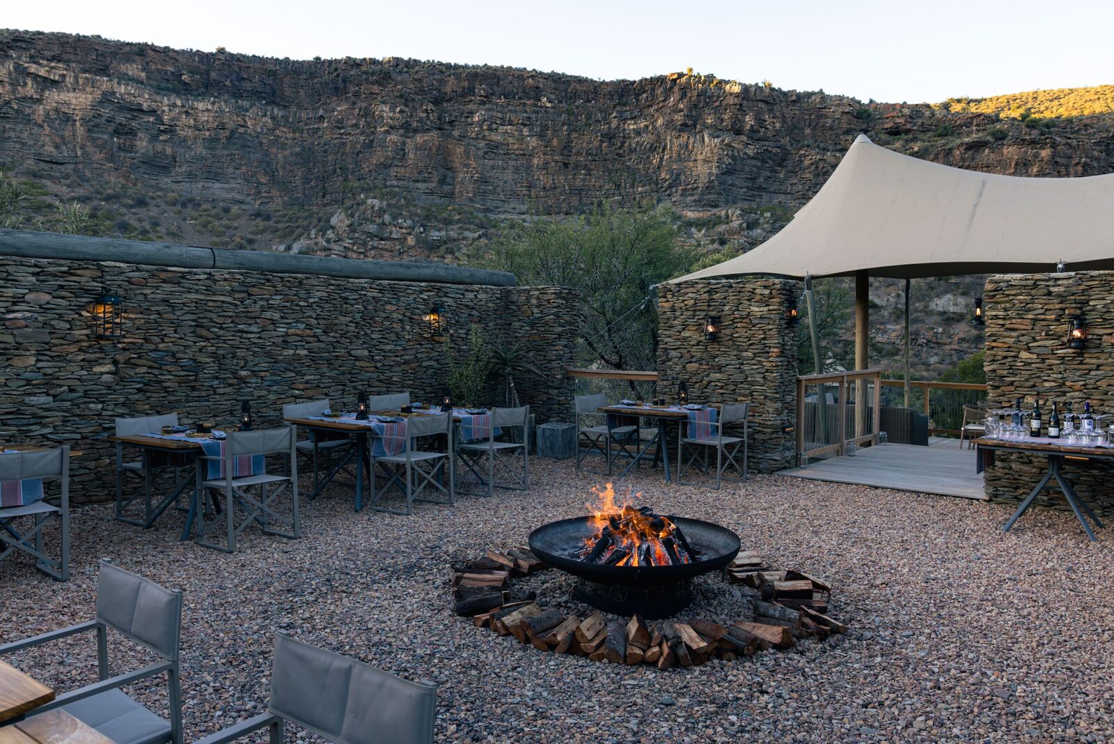 Firelit boma dinner setting beneath the cliffs at Dwyka Tented Lodge, Sanbona