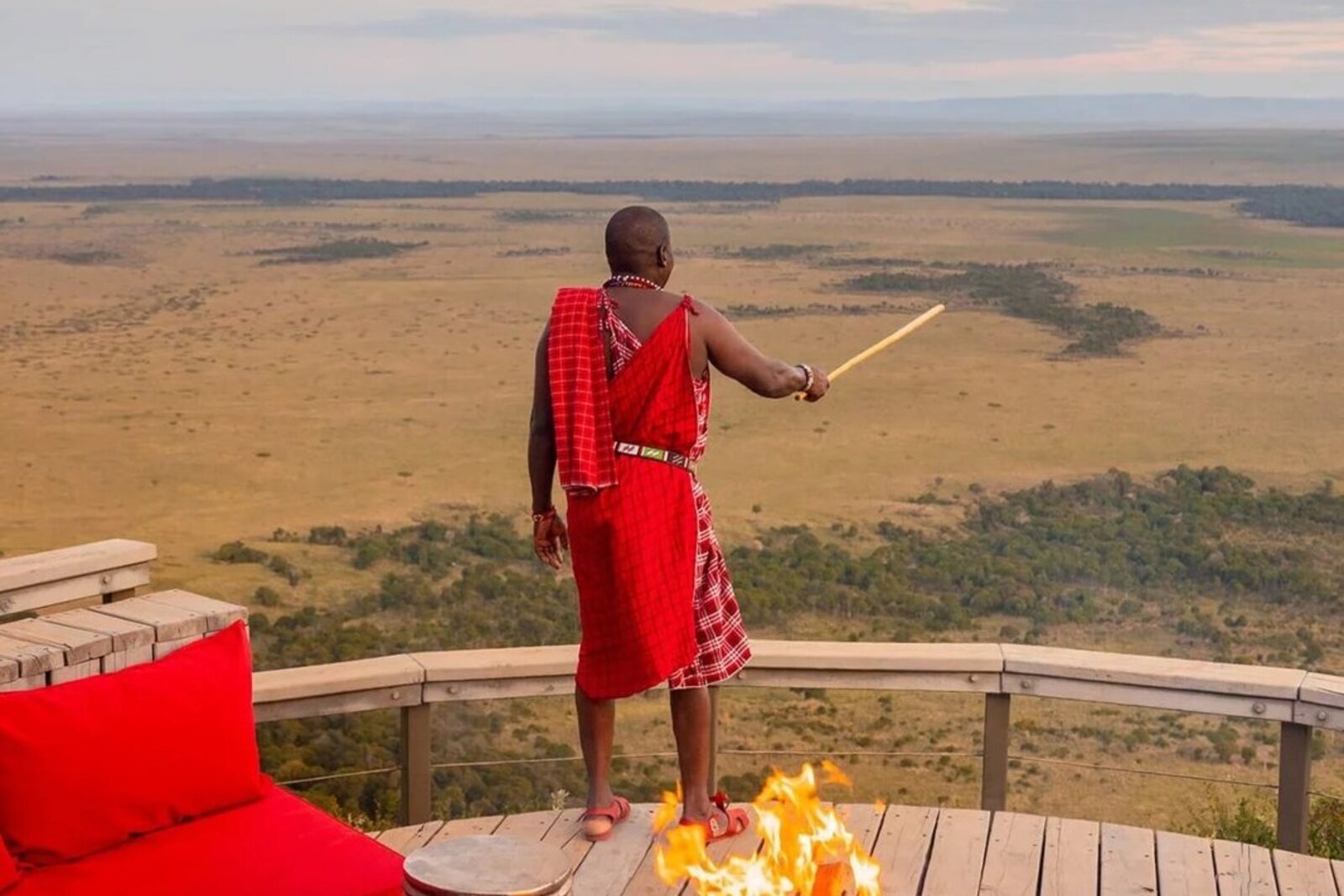 Guests around a fire pit at sunset on an African safari holiday