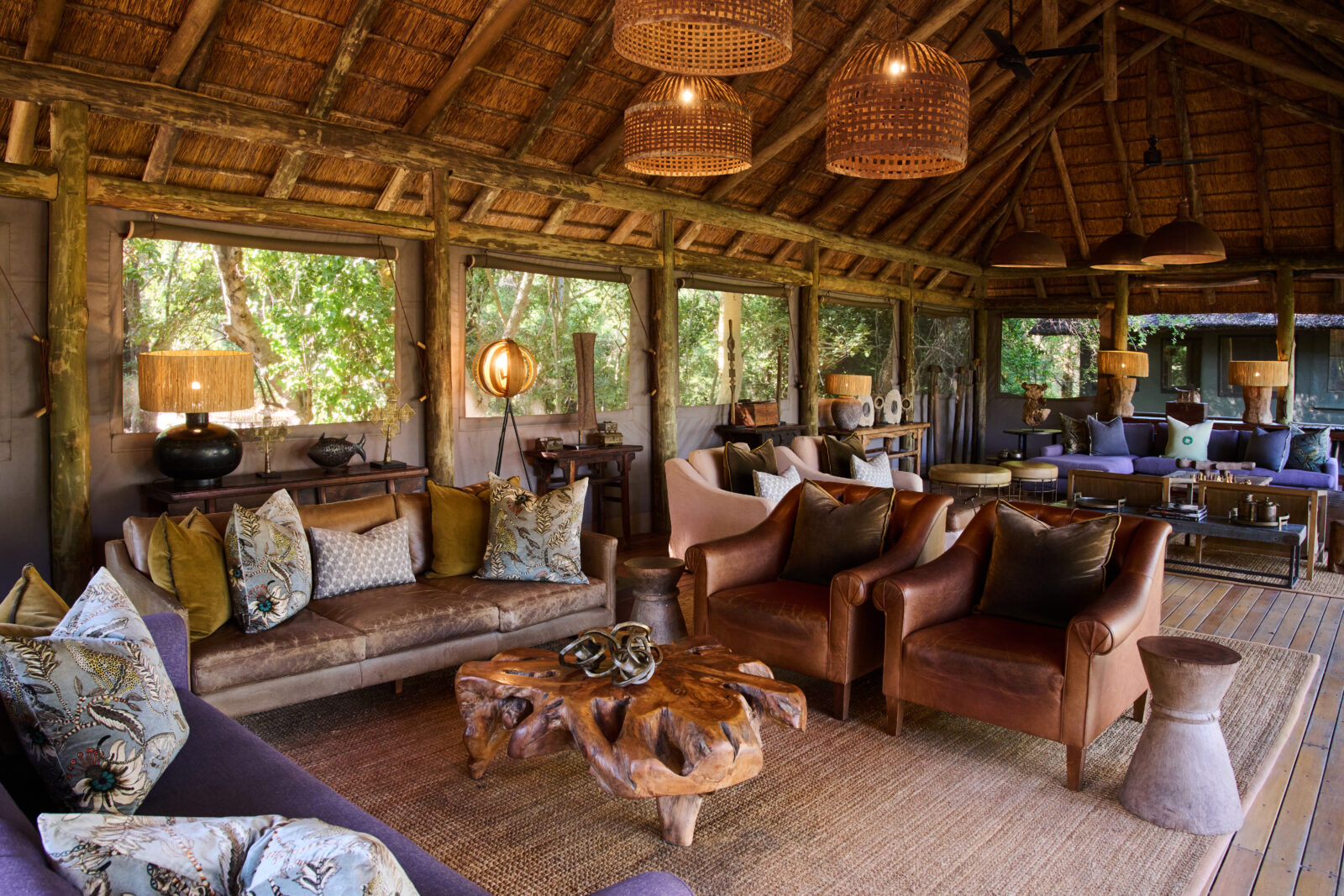 The raised main lounge at Camp Moremi shaded by giant ebony trees
