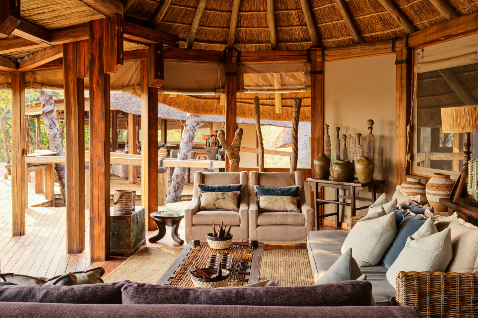 The main lounge and dining area at Camp Okavango, shaded by riverine trees