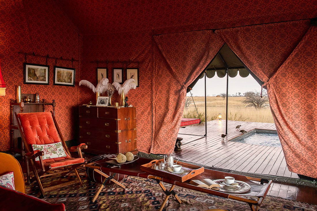 A guest tent lined with rich textiles and Persian rugs at Jack’s Camp