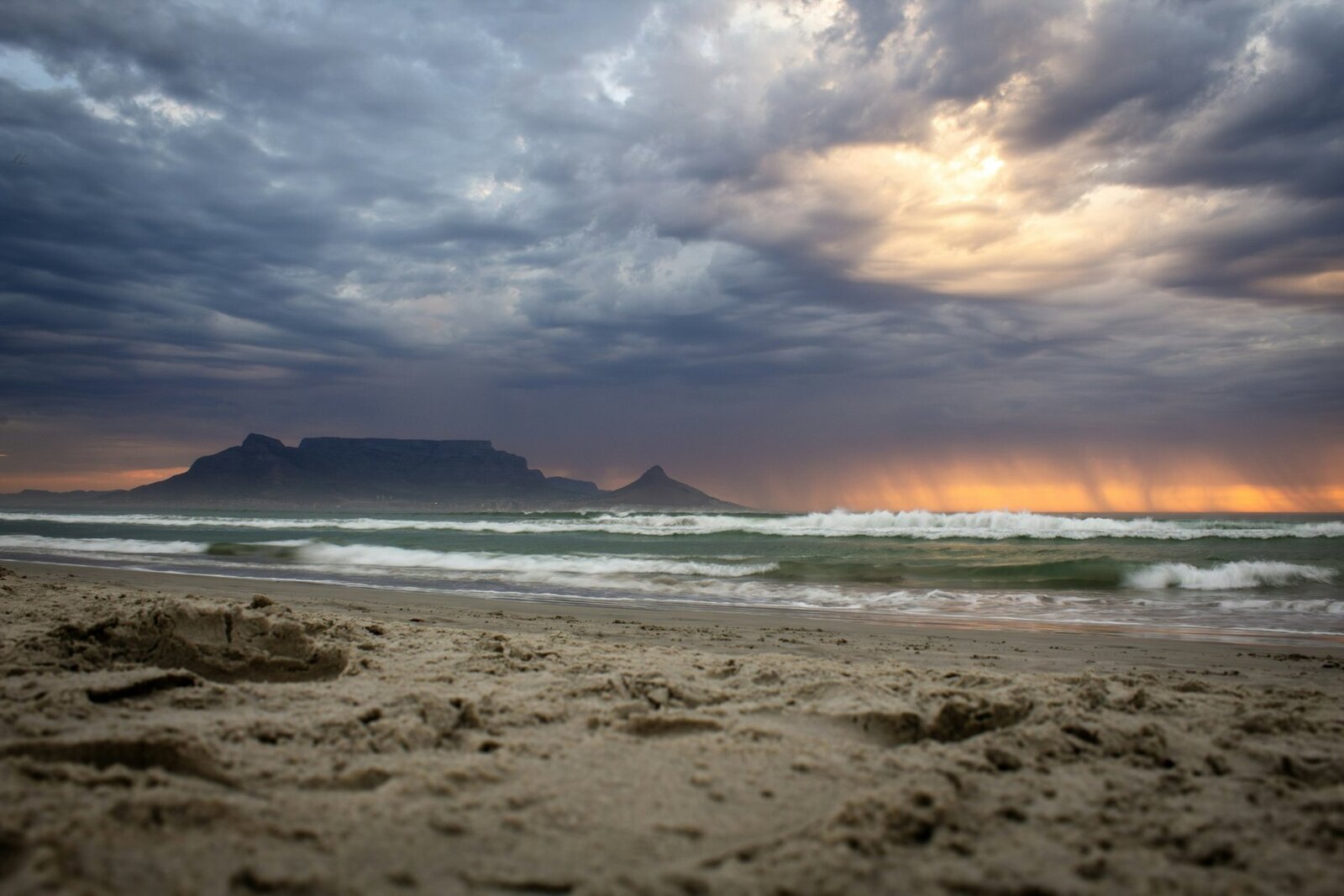 Table Mountain glowing warm above Cape Town at sunset seen from Table Bay
