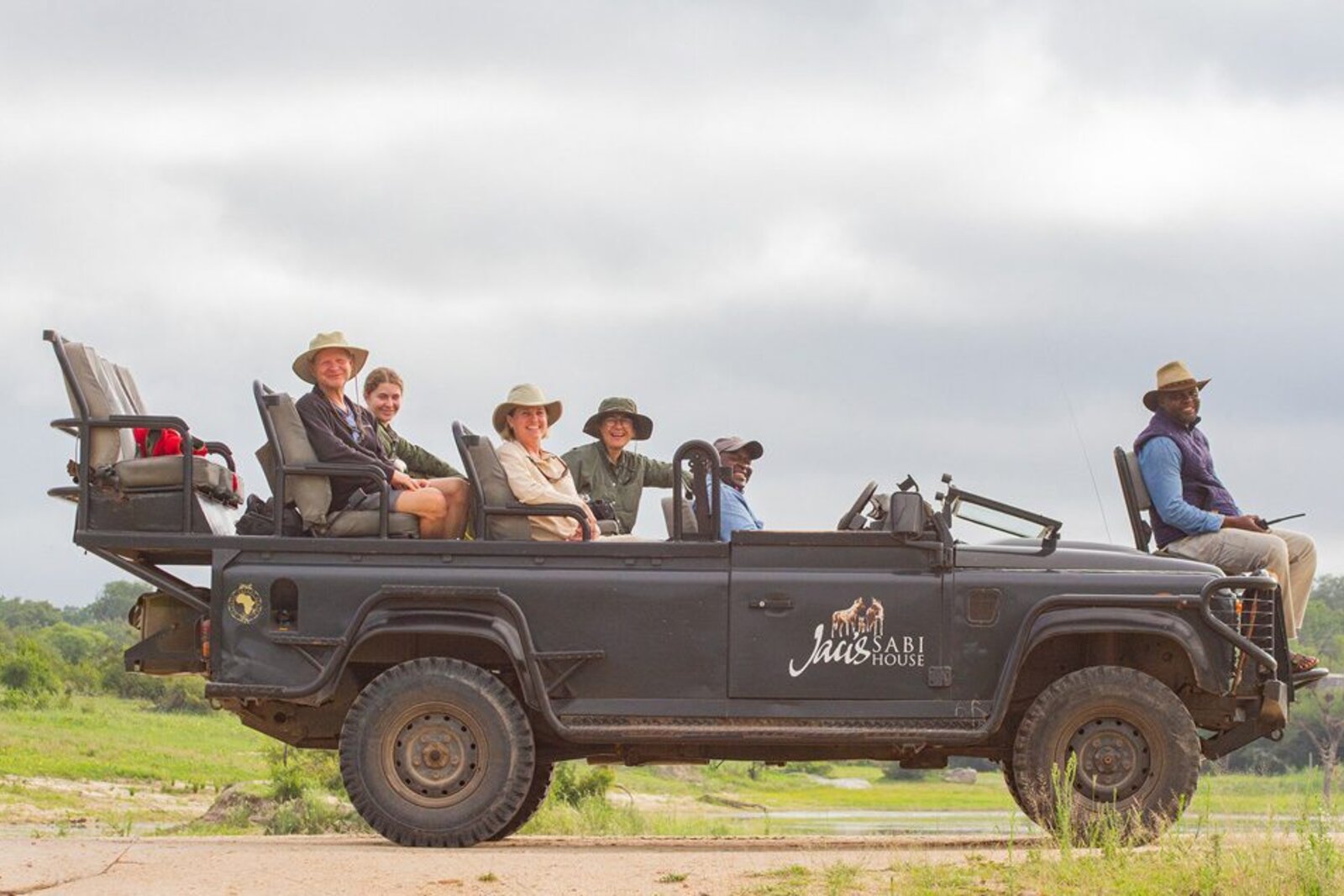Guests on an open game drive vehicle on a value all-inclusive Greater Kruger safari