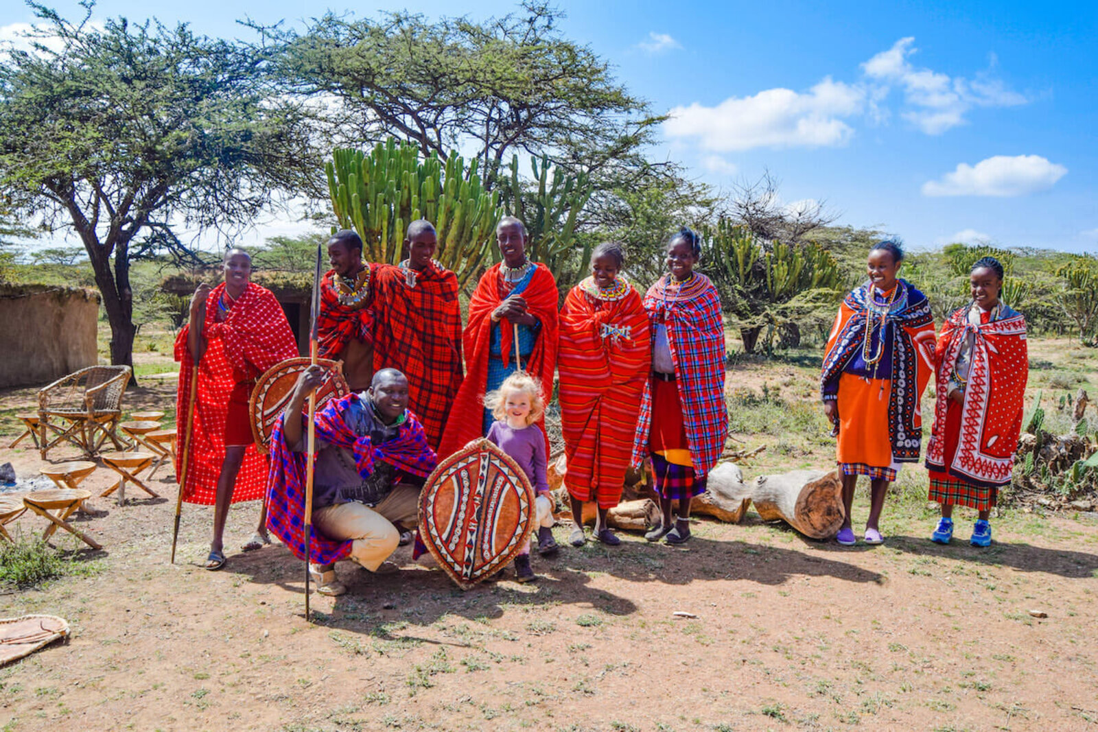 Maasai hosts in traditional red shukas gather for a group portrait near Amboseli