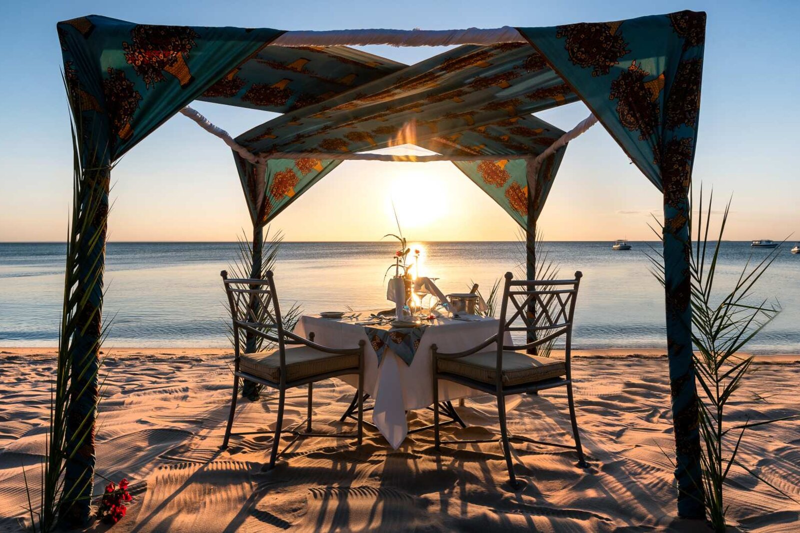 An Anantara Dining by Design private dinner set on the beach at sunset, Bazaruto Island, Mozambique