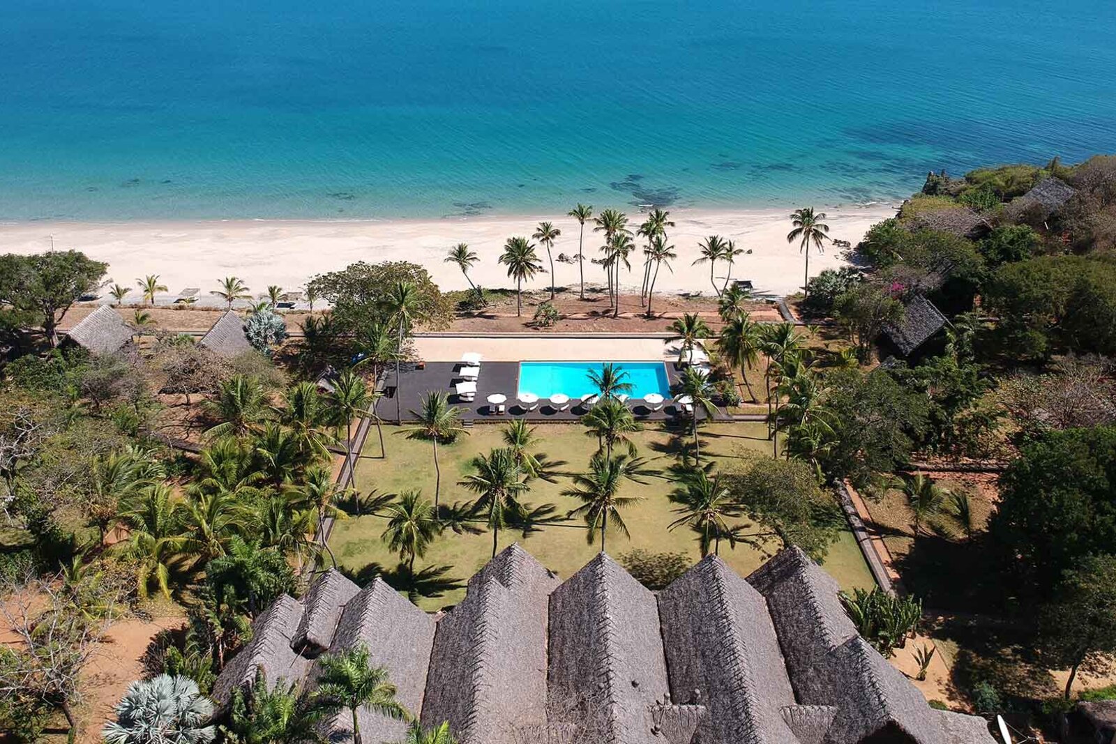 Aerial view of the lodge, pool and beach set against the forest and turquoise bay at Anjajavy, Madagascar