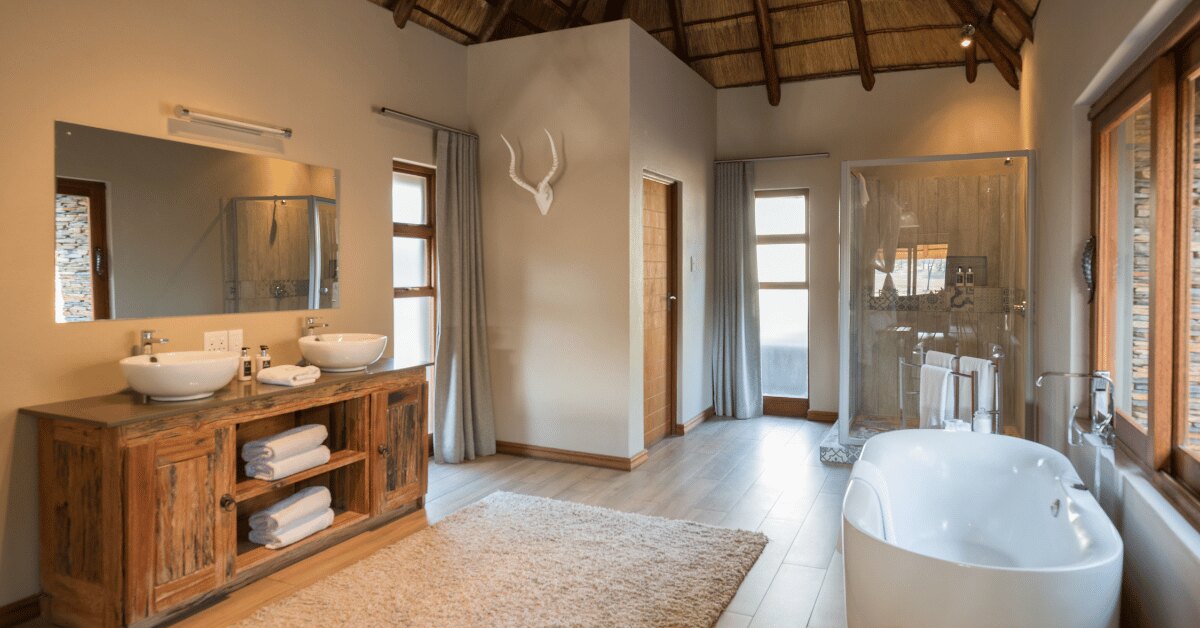 An Arathusa suite bathroom with a freestanding tub, twin basins and nyala-horn detailing