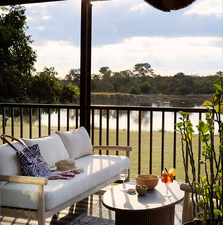 A deck sofa set for sundowners overlooking the Arathusa waterhole at dusk