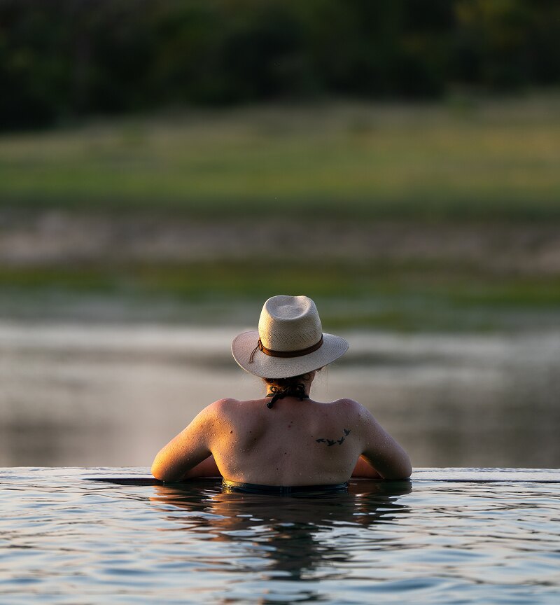 A guest in the Arathusa infinity pool set at the edge of the waterhole