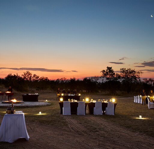 An open-air boma dinner set up at sunset at Arathusa Safari Lodge