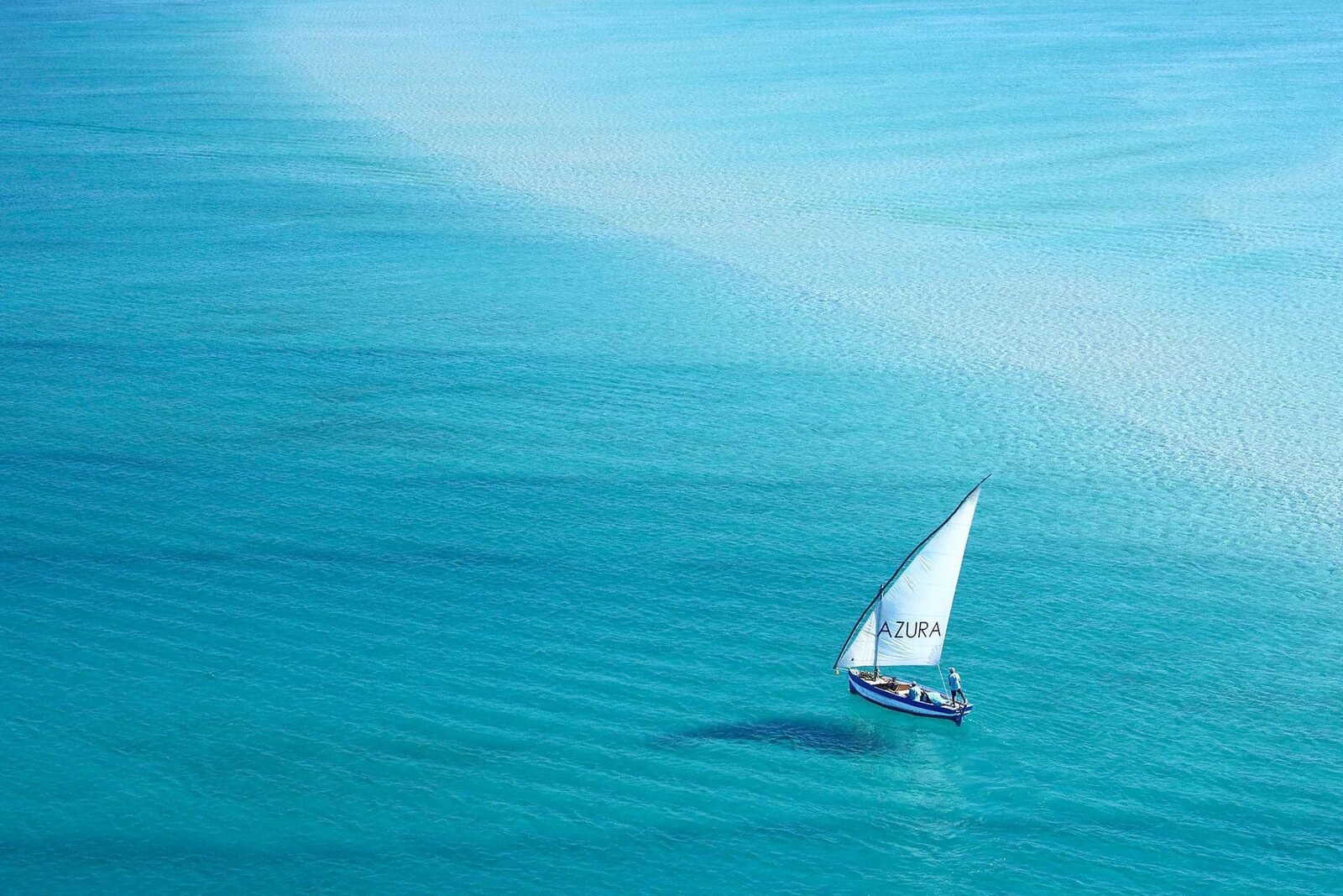 Azura Benguerra's traditional wooden dhow sailing on the turquoise water of the Bazaruto Archipelago, Mozambique