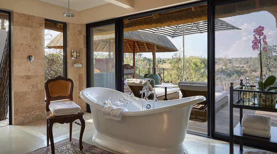 An opulent suite interior at Royal Malewane with Persian rugs and antiques