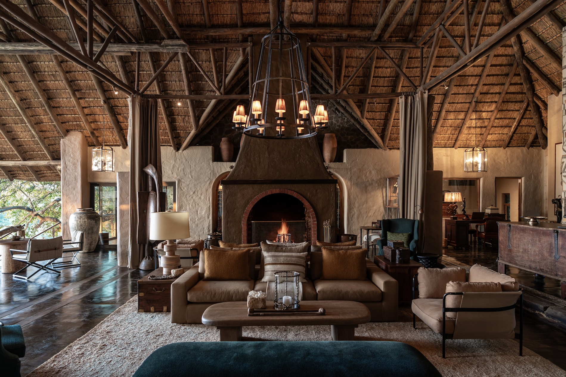 The grand fireplace lounge at Singita Ebony Lodge overlooking the bush