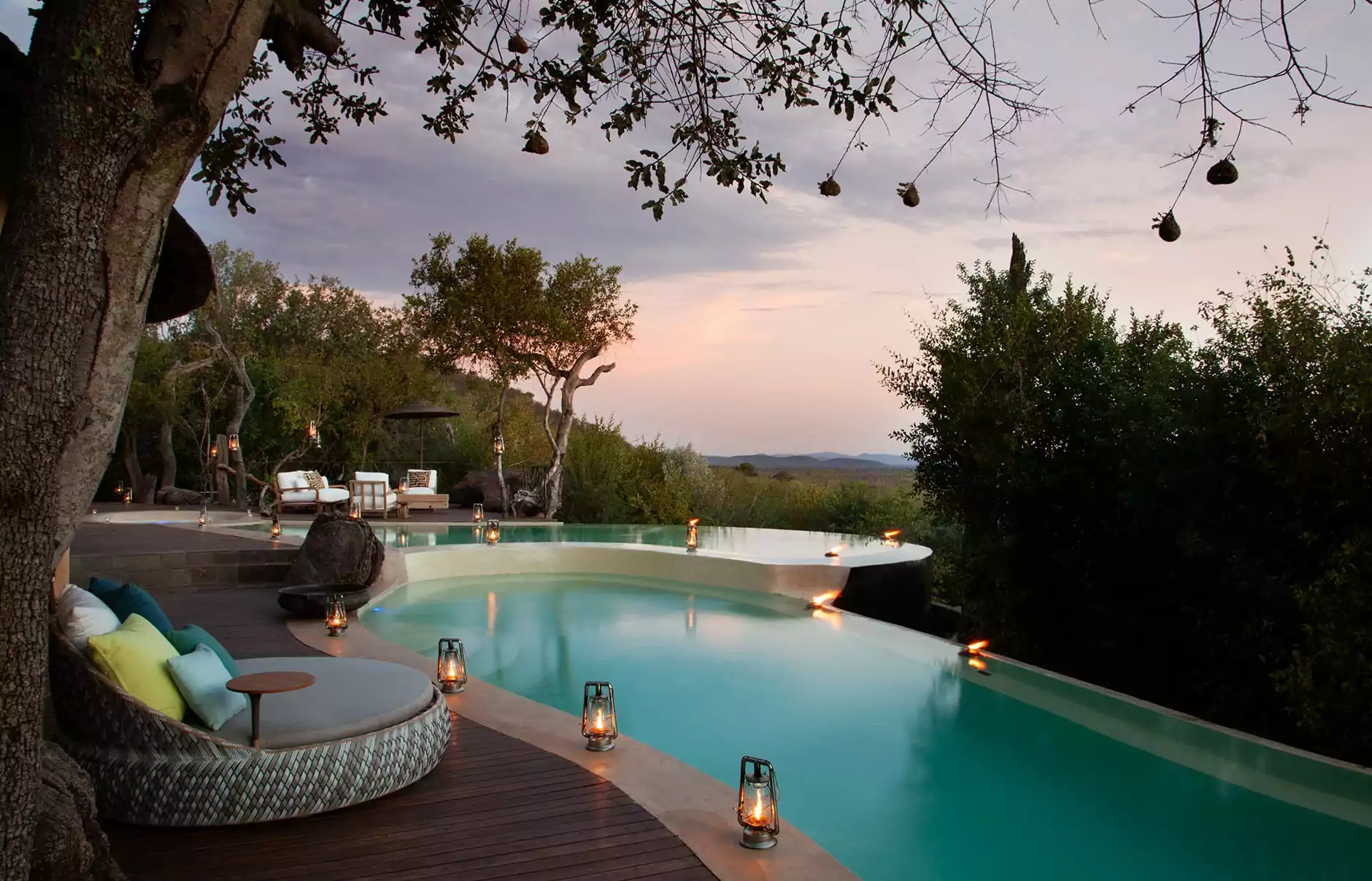 The infinity pool at a luxury safari lodge overlooking the African bushveld at sunset