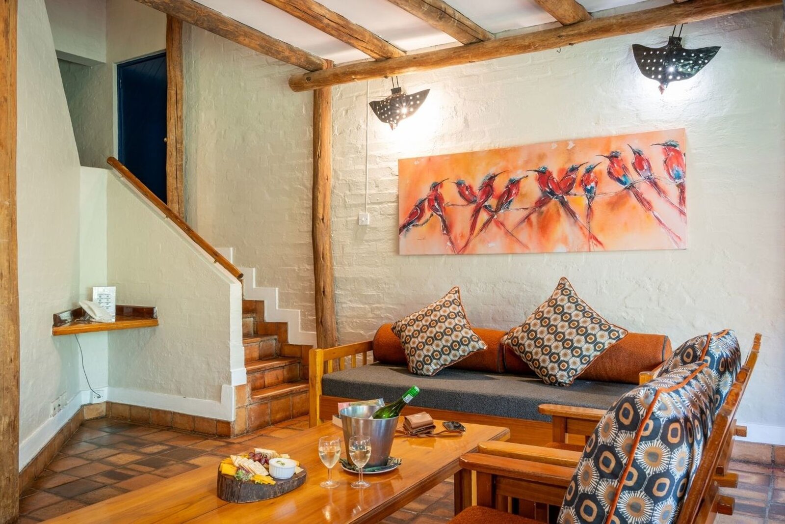 Open-plan lounge with double-volume thatch and African art inside a Lokuthula self-catering lodge, Victoria Falls