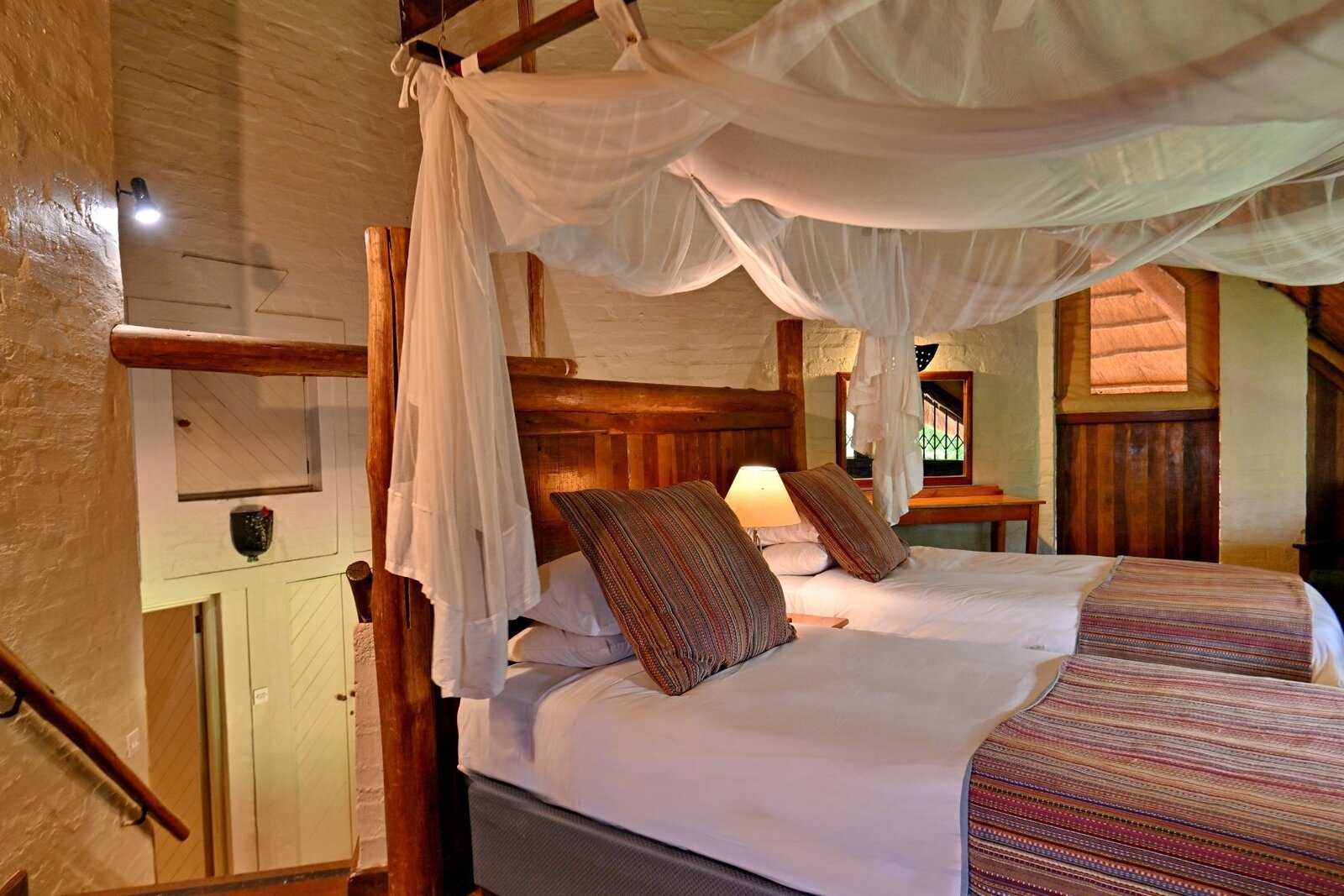 Twin bedroom with mosquito nets in an upstairs room at Lokuthula Lodges, Victoria Falls