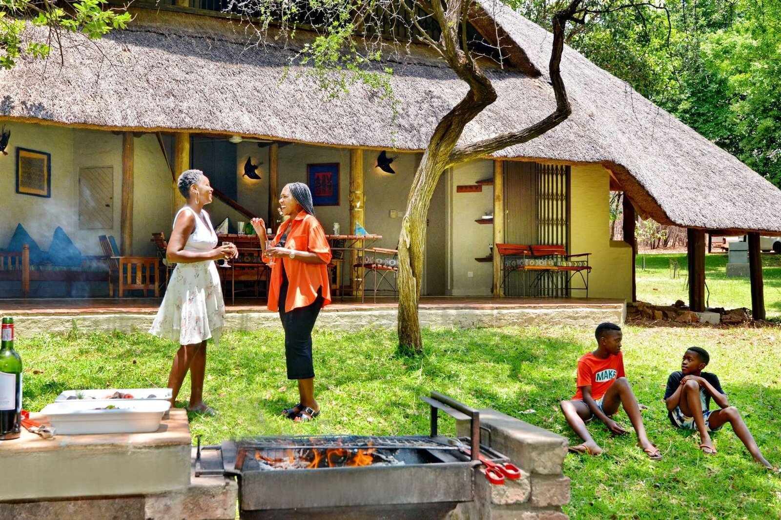 Family enjoying a braai on the lawn outside their Lokuthula lodge near Victoria Falls