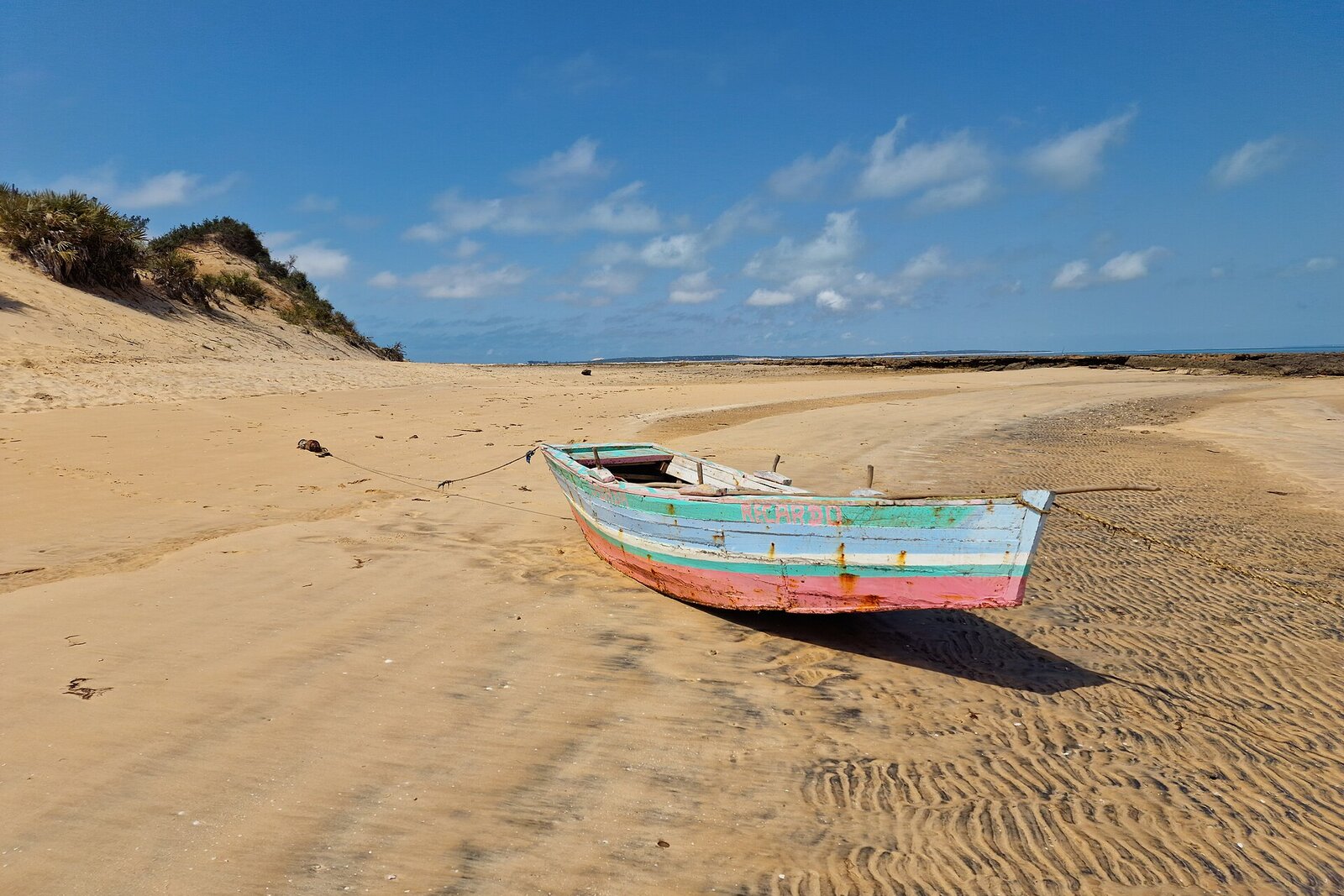 A wooden fishing boat on the golden dunes and white sand of Bazaruto Island, Mozambique