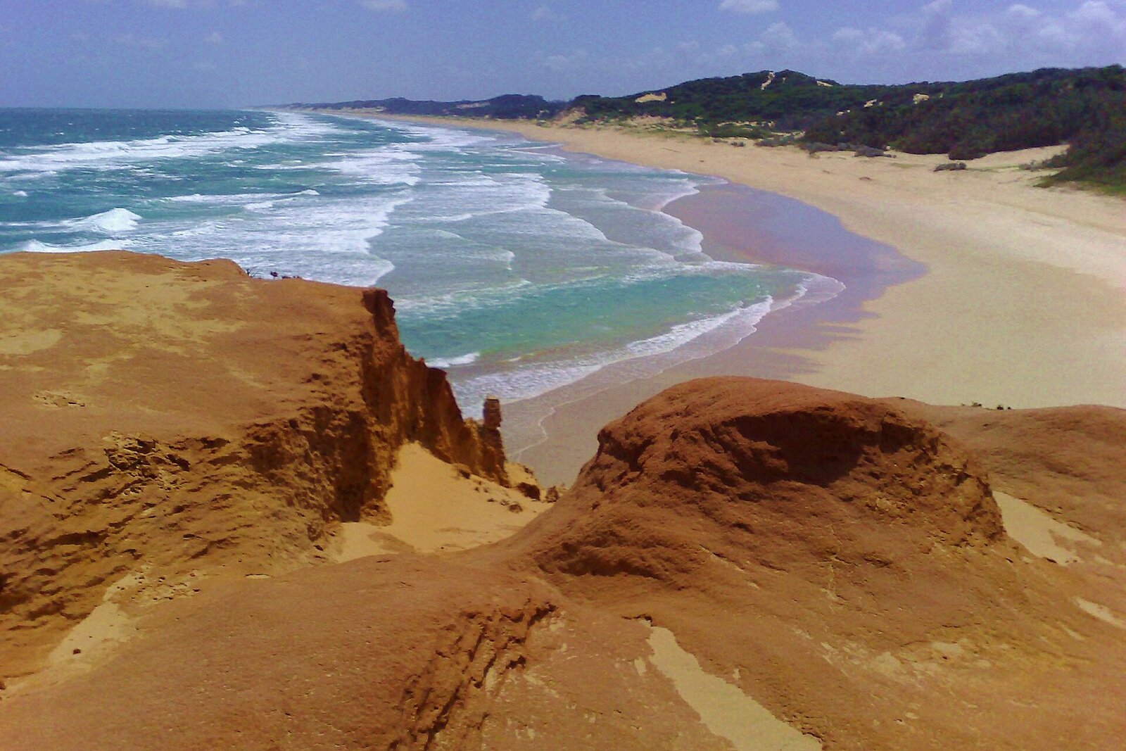 Dramatic dune cliffs above a long surf beach on the southern coast of Mozambique