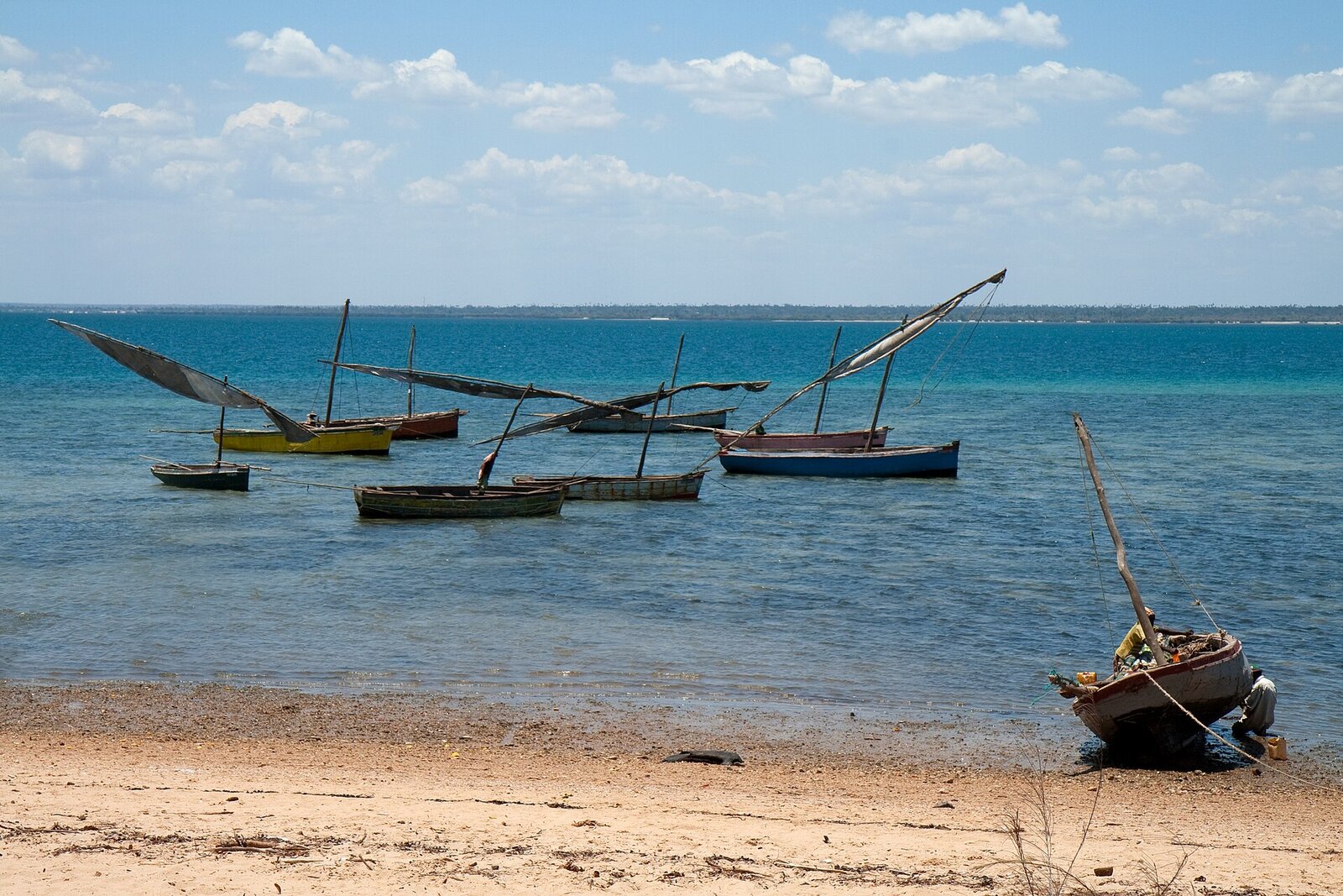 Traditional dhows resting on the sand at low tide on the Mozambique coast