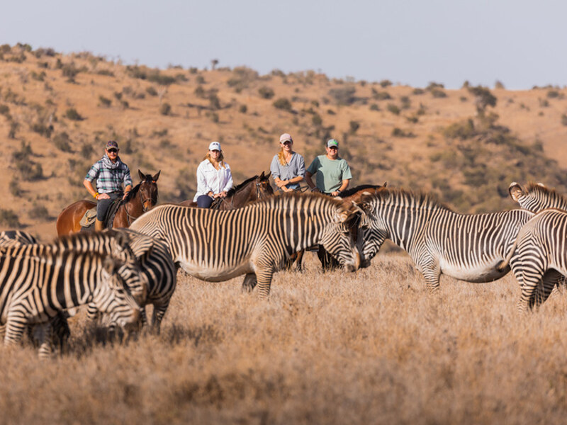 Horseback riders at Lewa Wilderness with Mount Kenya visible in the background