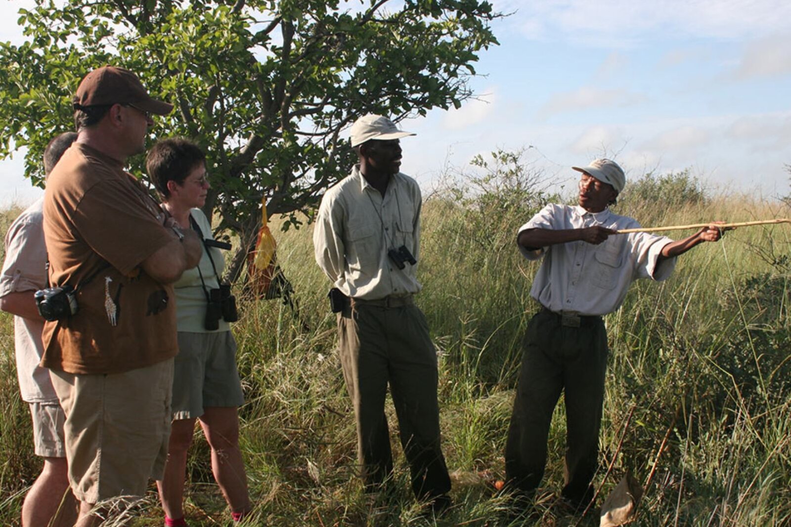 San guide pointing across the Kalahari on a walking safari near Tau Pan