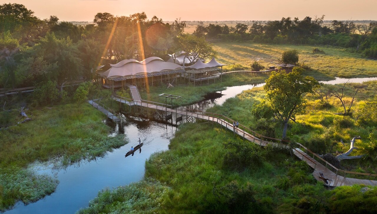 Aerial view of Xigera Safari Lodge over the Okavango Delta at sunset