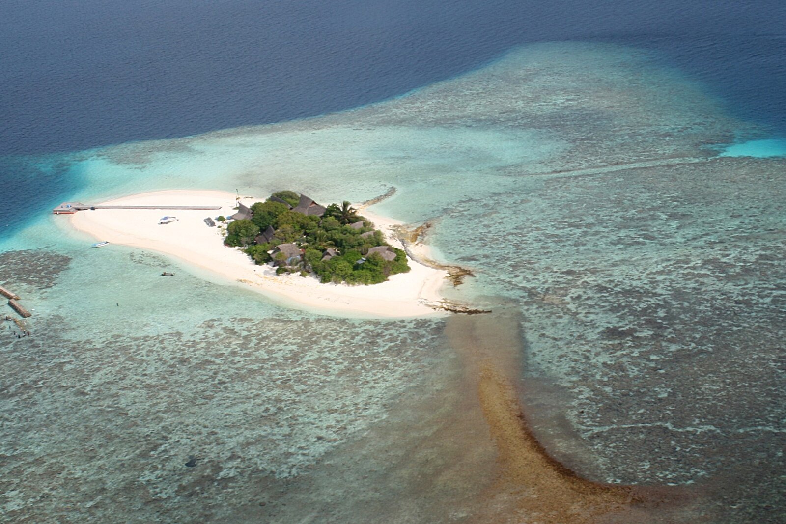 Aerial view of a small Maldivian island and sandbank inside a coral atoll