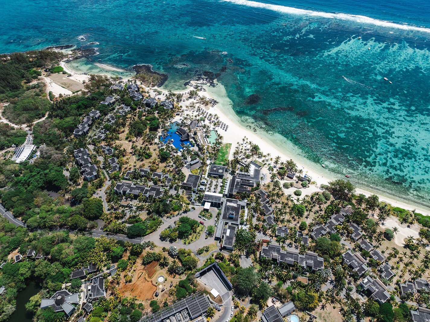 Aerial view of a Mauritius beach resort and lagoon; the sheltered west coast stays calm through the summer