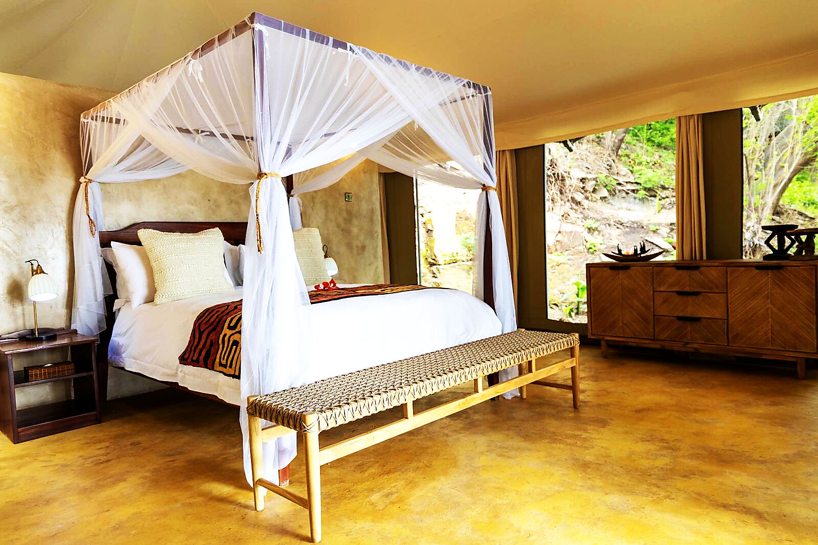 A netted four-poster bed in a luxury island tent