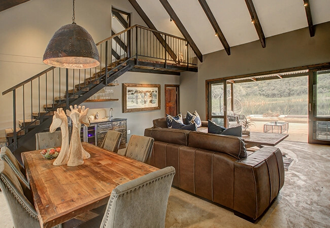 Botlierskop Bush Villa lounge with fireplace and reserve views