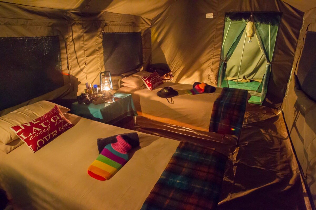 Interior of a mobile safari tent with a proper bed and cotton linen
