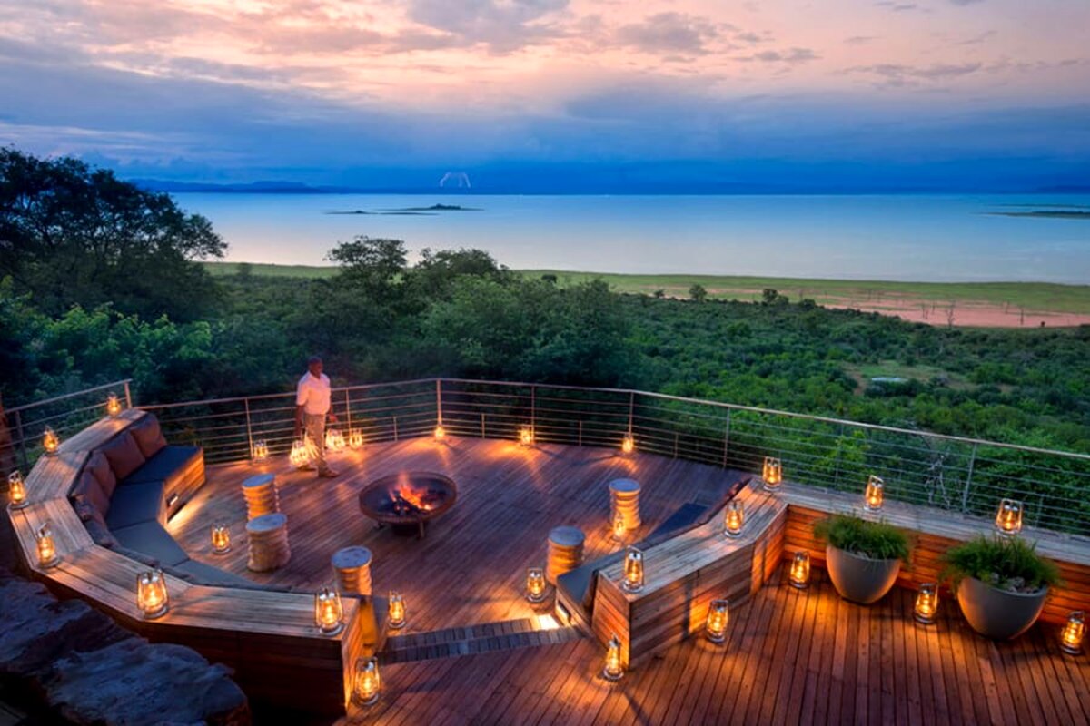 Circular firepit boma deck at sunset with lanterns above Lake Kariba