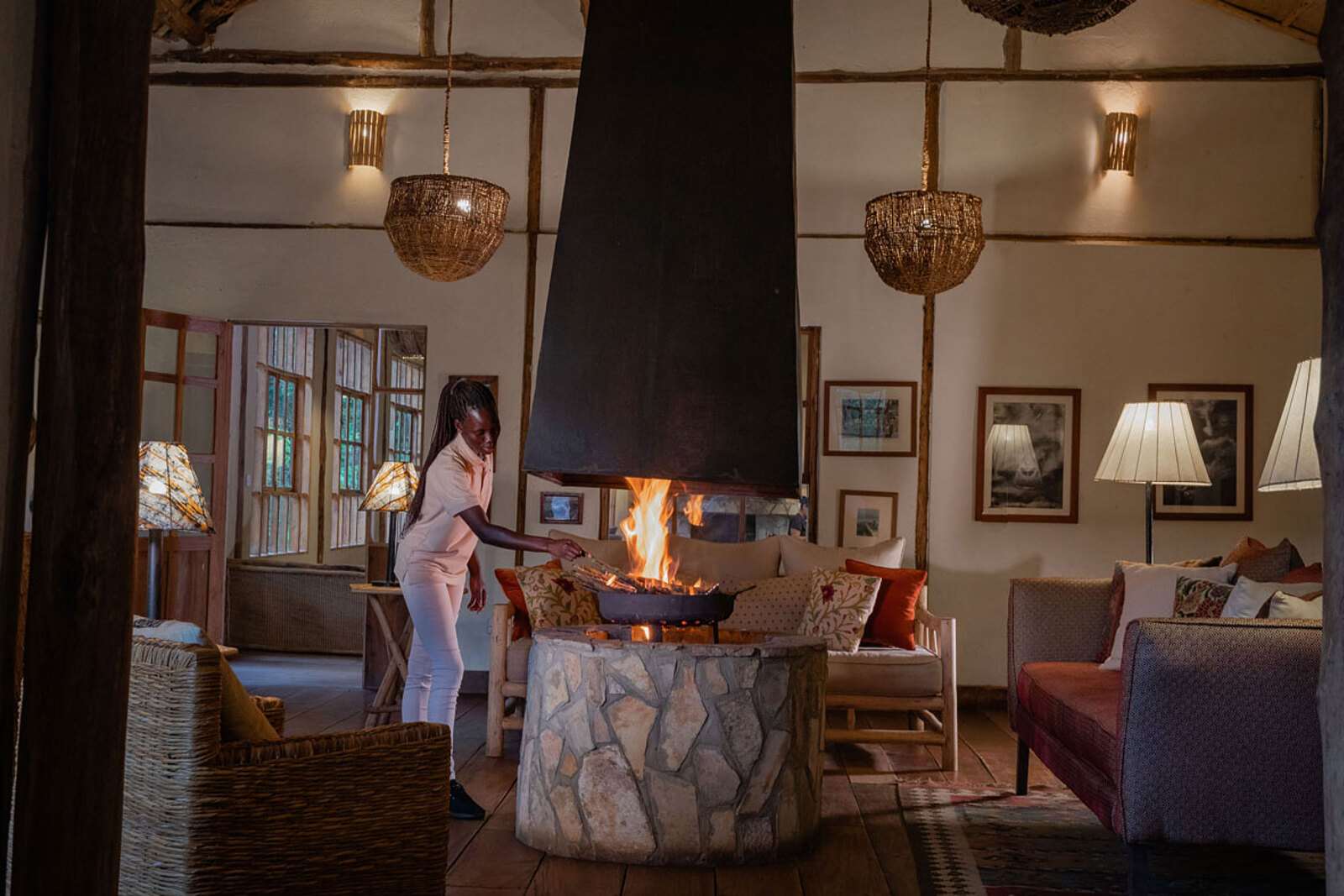 Bwindi Lodge main lounge with central stone fireplace