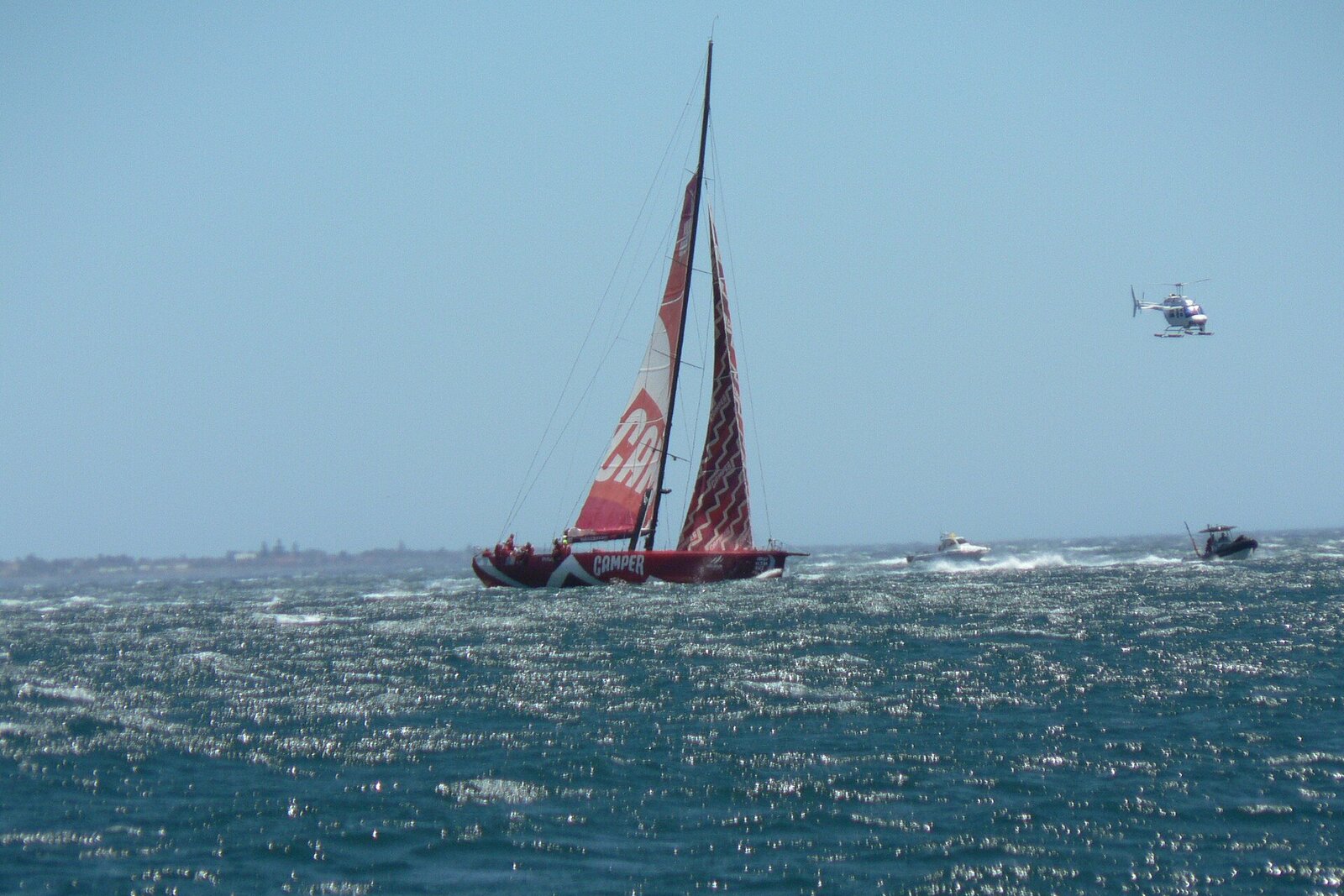 A catamaran sailing off the Cape Town coast at golden hour