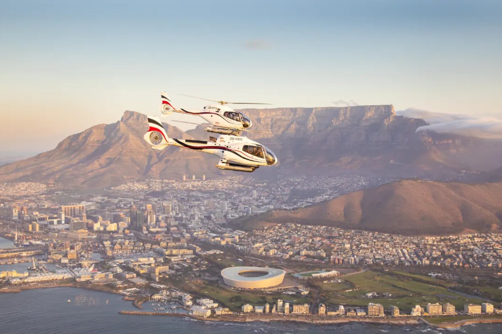 Helicopter flying low over Cape Winelands vineyards and mountains
